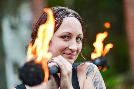 Fire show girl with flaming torchesの写真素材