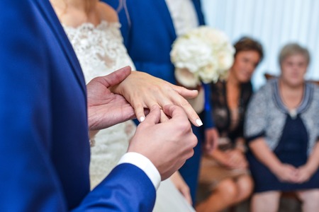 marriage hands with rings. birde wears the ring on the finger of the groomの写真素材