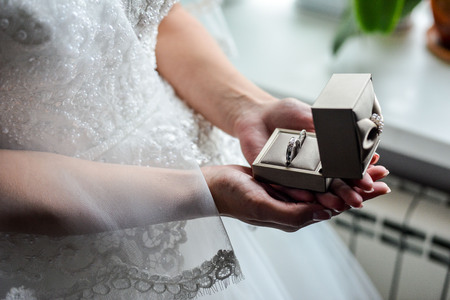 Engagement ring box in bride hands. Closeup of woman palms holding jewellery.の写真素材