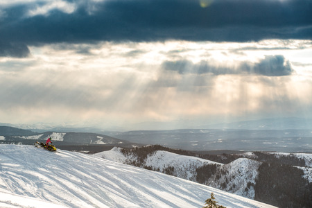 Rider on the snowmobile in the mountainsの写真素材