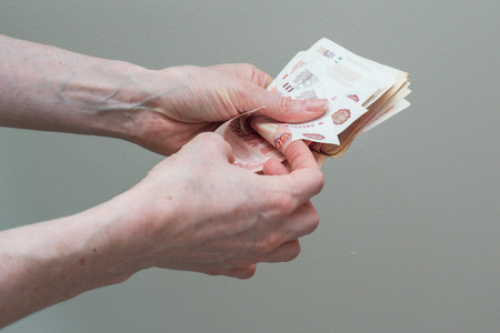 children's and woman's hand with stack of Russian moneyの写真素材