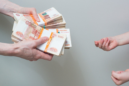 children's and woman's hand with stack of Russian moneyの写真素材
