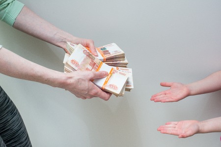 children's and woman's hand with stack of Russian moneyの写真素材
