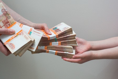 children's and woman's hand with stack of Russian money