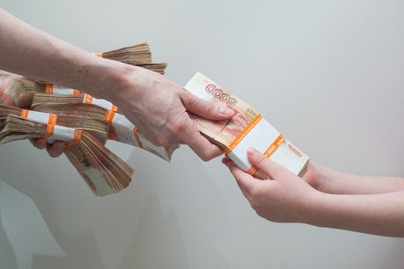children's and woman's hand with stack of Russian money