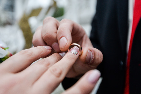 Wedding day. The groom places the ring on the brides hand. Photo closeupの写真素材