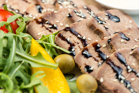 tongue dish boiled with salad in white plate on white backgroundの写真素材