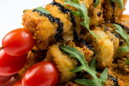 vegetables on skewer fried in batter decorated with tomatoes zucchini, eggplant, zucchini. white plate on white backgroundの写真素材