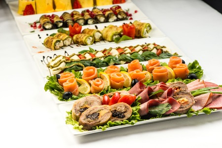 Different snacks for eating on holiday in white plates on white background. Kitchen, menu, food...