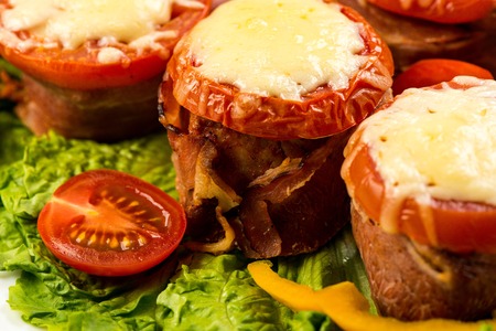 Delicious meatloaf with spinach, cheese and tomato on plate on white backgroundの写真素材