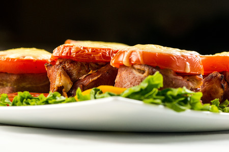 Delicious meatloaf with spinach, cheese and tomato on plate on white backgroundの写真素材
