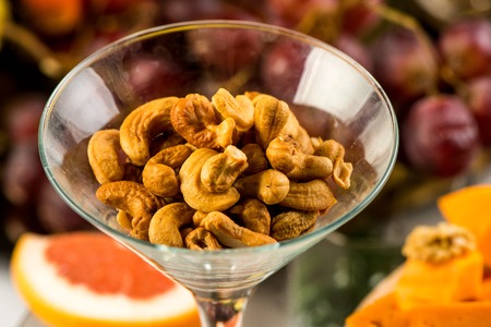 roasted peanuts isolated in glass bowl, on white backgroundの写真素材