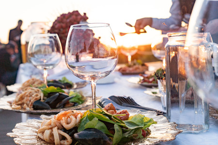 Couple enjoying wine against a beautiful sunset.の写真素材