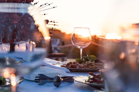 Couple enjoying wine against a beautiful sunset.の写真素材