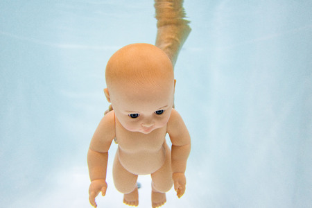 baby doll under water . bathing baby under water.の写真素材