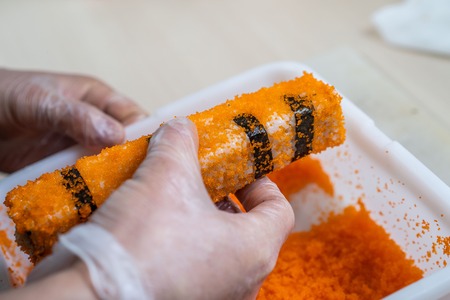 Cook hands making japanese sushi roll. Japanese chef at work preparing delicious sushi roll with eel and avocado. Appetizing japanese food.の写真素材