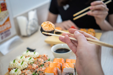 girl eating sushi set with chopsticks on restaurant . close upの写真素材