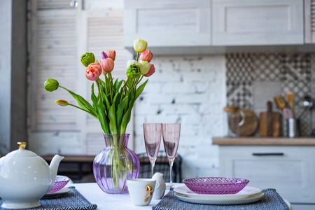 Glass vase with bouquet of beautiful tulips on brick wall backgroundの写真素材
