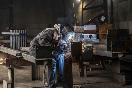 Welding with sparks by Process fluxed cored arc welding ,Industrial steel welder part in factory welder Industrial automotive part in factory.の写真素材