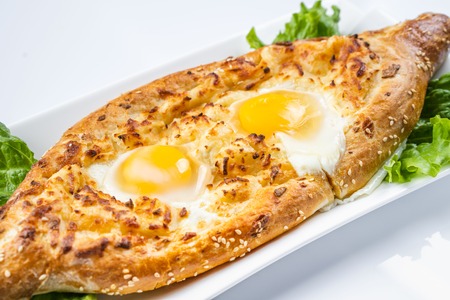 Khachapuri in Adjarian. Open pie with mozzarella and egg. Georgian cuisine.