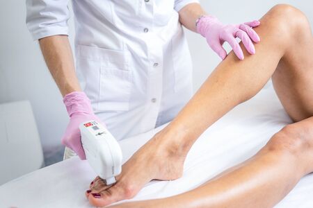 Laser hair removal on womens legs . white background close upの写真素材