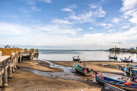 Fishing boats on the shore at low tide . Thailandの写真素材