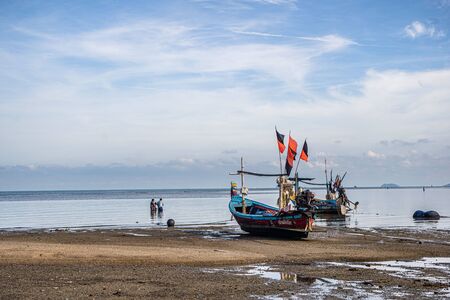 Fishing boats on the shore at low tide . Thailand