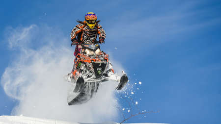 Athlete on a snowmobile moving in the mountainsのeditorial素材