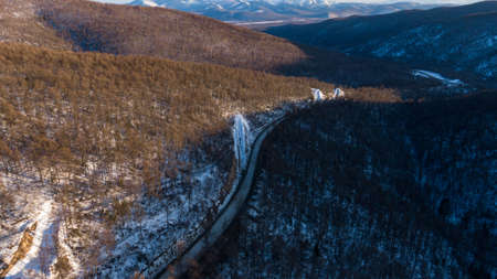 Aerial view of the river and taiga forests and road in the winter - springtime . Abstract landscape of northern nature with drone.の写真素材