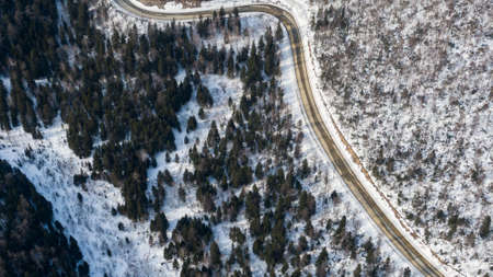 Aerial view of the river and taiga forests and road in the winter - springtime . Abstract landscape of northern nature with drone.の写真素材