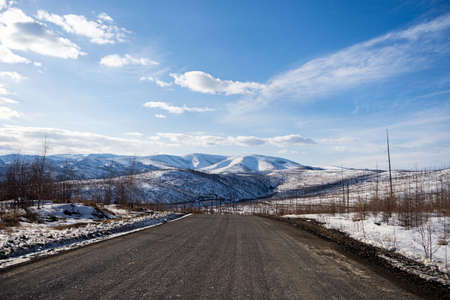 Aerial view of the river and taiga forests and road in the winter - springtime . Abstract landscape...