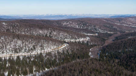 Aerial view of the river and taiga forests and road in the winter - springtime . Abstract landscape of northern nature with drone.の写真素材