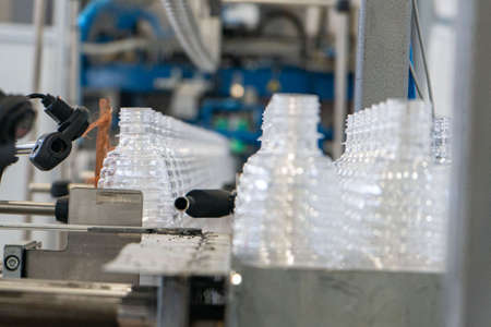 The various type of plastic bottle product and preform material with injection mold background. Drinking container manufacturing processing.の写真素材