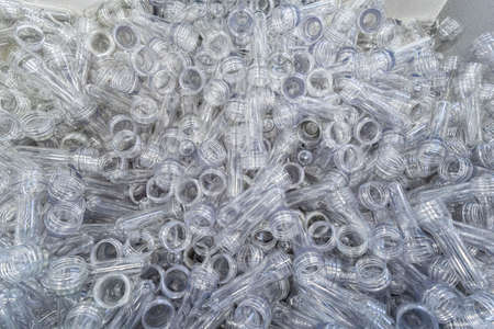 The various type of plastic bottle product and preform material with injection mold background. Drinking container manufacturing processing.の写真素材