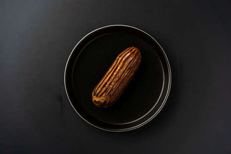 dessert is a small puff pastry pie with stuffing inside on a black serving plate on a black...