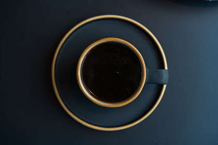 coffee in a black cup . Black coffee cup, on a black background. Space for text. top viewの写真素材