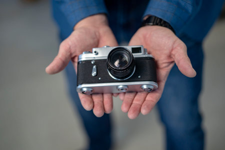 Male hands holding a vintage old cameraの写真素材