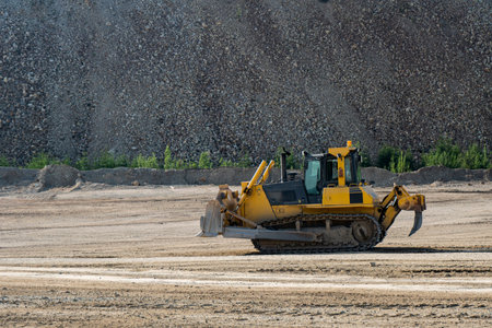Bulldozer at a construction site shovels mountain soil into a heapの写真素材
