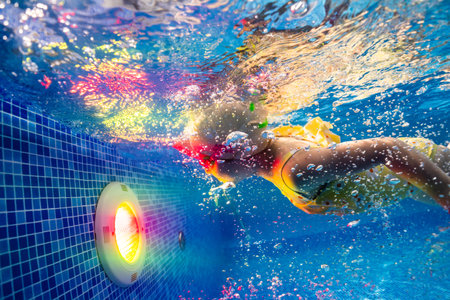 Little child swims underwater in swimming pool, happy active dives and has fun under water, kid fitness and sportの写真素材
