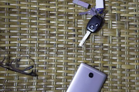Remote car key, mobile phone on vintage table.の写真素材