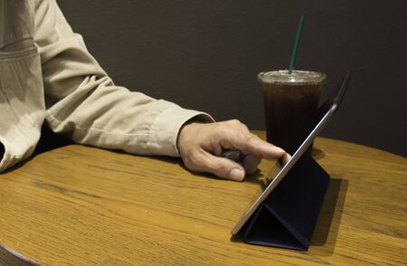 Man play tablet in coffee shop.の写真素材