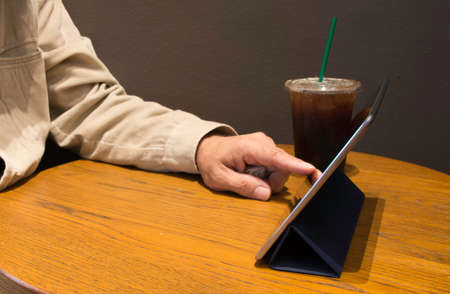 Man play tablet in coffee shop.の写真素材