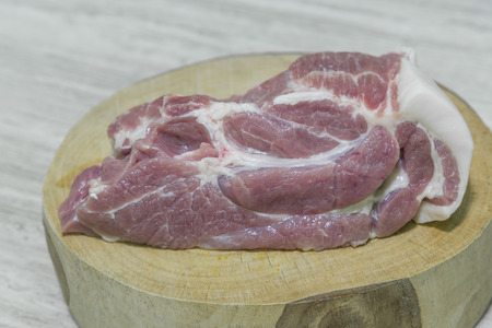 Raw pork chops on chopping board for cooking.の写真素材
