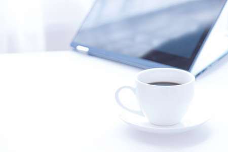 Cup of coffee and modern touch screen notebook.の写真素材