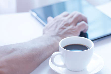 Cup of coffee and modern touch screen notebook.の写真素材