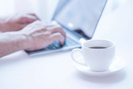 Cup of coffee and modern touch screen notebook.の写真素材