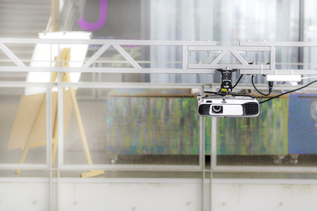 White projector hangs on the rail for learning and entertainment.