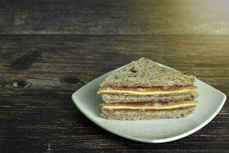 Sandwich ham cheese with Whole wheat Bread made from Riceberry on dark background.