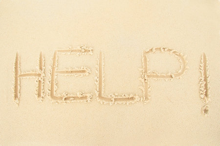 Help, word written on the sand.の写真素材