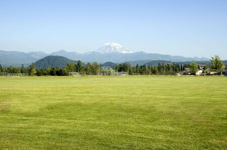 Mount Rainier looms large over the sports fields in this rural Washington town.の写真素材